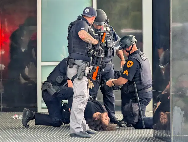 A man is detained by City Police after the Salt Lake City shooting occurred during a rally on Saturday, June 14, 2025. (Image Credit: Chad Thaxton)