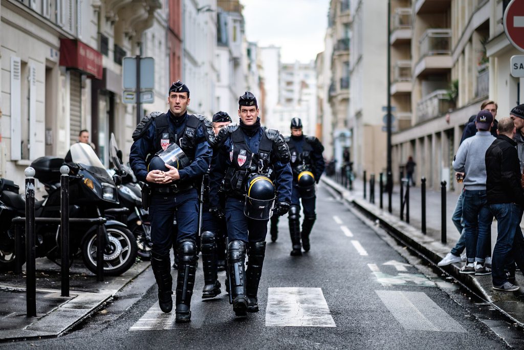 Police officers in riot gear firing teargas canisters during France protests in Paris