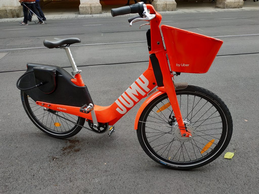 Electric bicycle parked on sidewalk near hospital entrance