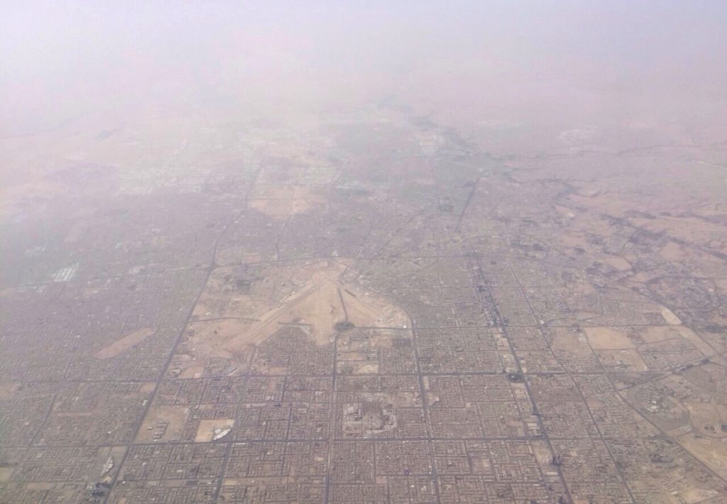King Khalid International Airport terminal exterior with smoke in the background
