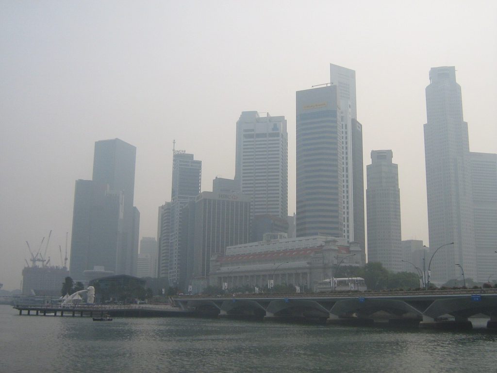 Thick toxic haze obscuring a city skyline during the Indonesia haze crisis