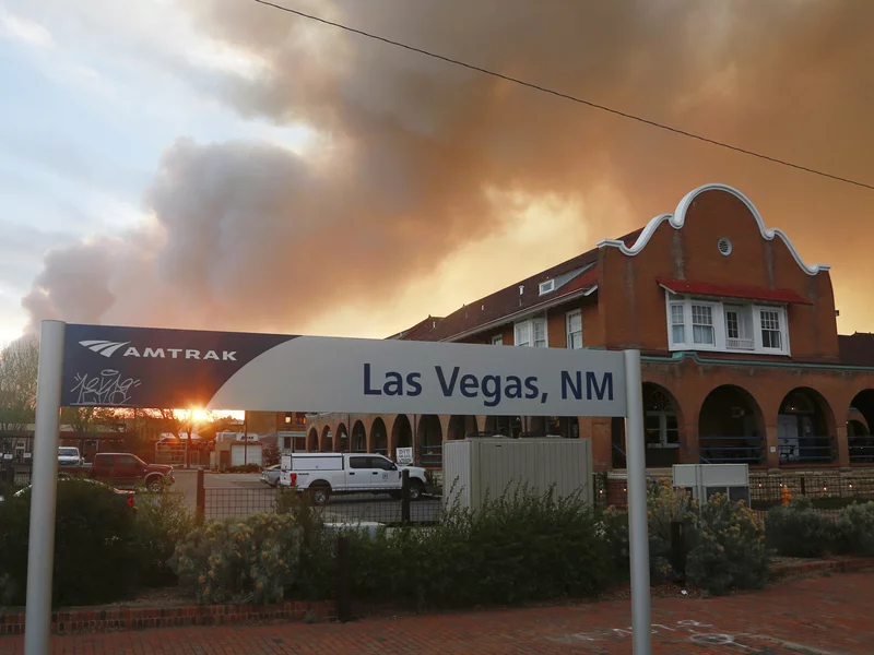 A sunset seen through a wall of wildfire smoke from the Amtrak train station in Las Vegas on Saturday. The Castañeda Hotel, right, hosted meals for residents and firefighters this week with sponsorships from restaurants and other businesses. (Credit: Attanasio / Associated Press)