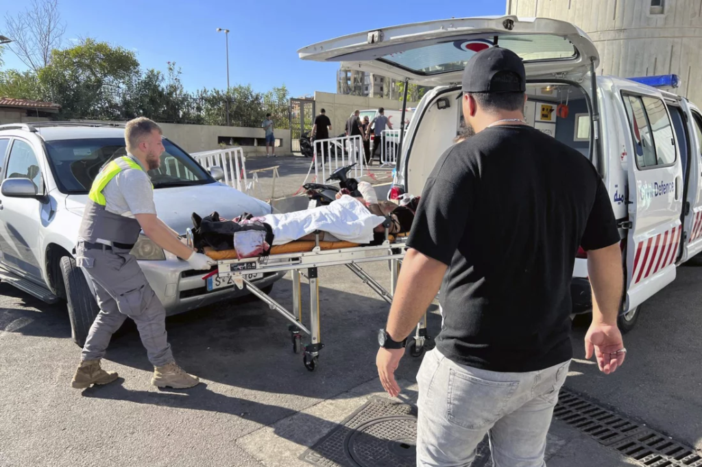 Explosive Pager Attack on Hezbollah: A New Phase in Israeli-Hezbollah Tensions 2 Civil Defense first-responders carry the wounded whose pager exploded at al-Zahraa hospital in Beirut, Lebanon, Tuesday, Sep. 17, 2024. (Image Credit: Hussein Malla / AP)