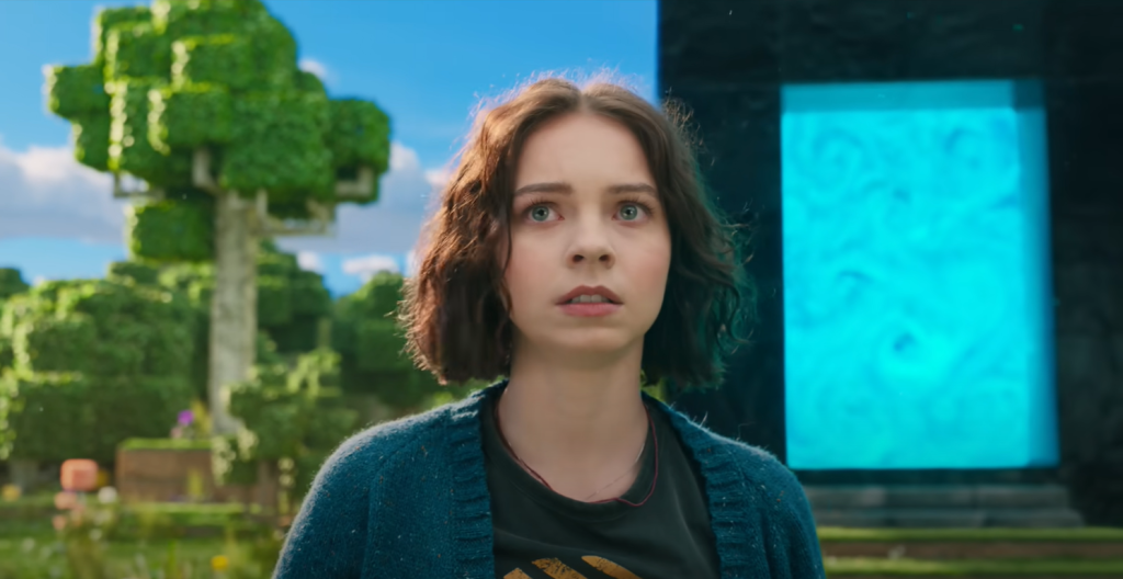 First Official ‘Minecraft Movie’ Trailer Sparks Controversy 2 Emma Myers as Natalie who got transported to the Minecraft Overworld by the Blue Nether Portal made out of Obsidian behind her. (Image Credit: Warner Bros.)