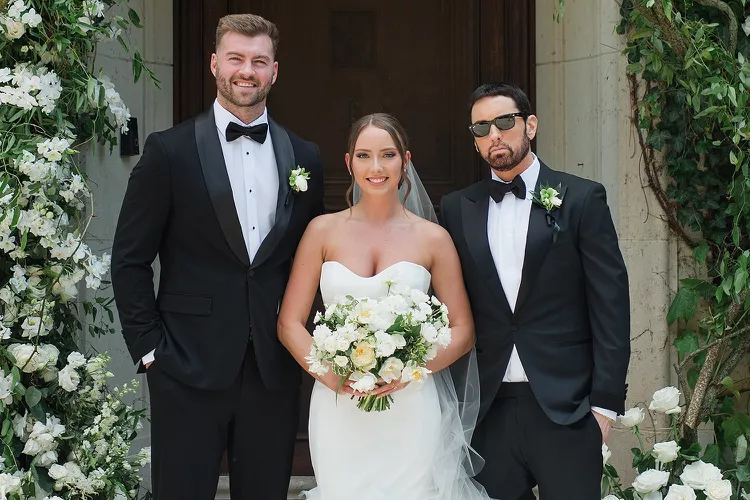 Newlyweds Hailie Jade Scott and Evan McClintock pose with Scott's father Eminem. (Image Credit: Instagram @erikachristinephoto)
