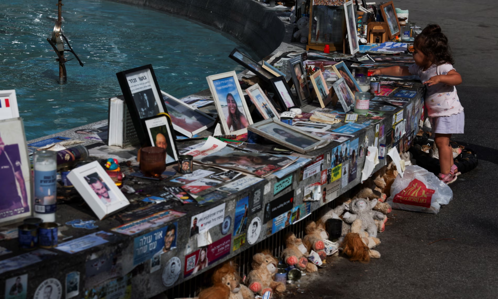A child vists a memorial for hostages taken during the 7 October attack, in Tel Aviv, Israel. (Image Credit: Shannon Stapleton/Reuters)