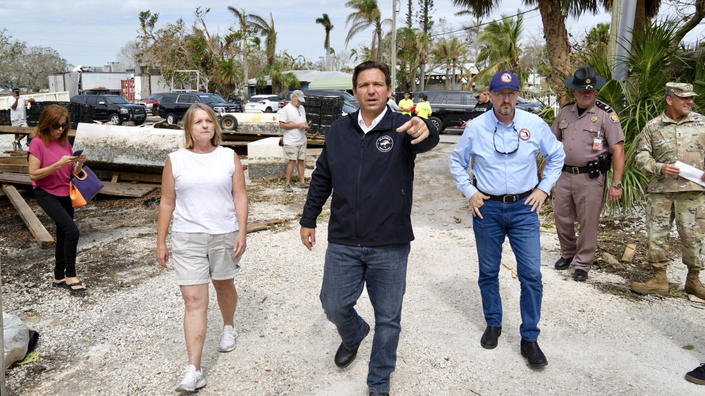 Hurricane Milton Damage: Death Toll Rises and FEMA Aid on the Horizon 1 Florida Governor Ron DeSantis (middle) amongst the wreckage of hurricane Milton damage in Bradenton Beach for relief efforts. (Image Source: Twitter / X @GovRonDeSantis)