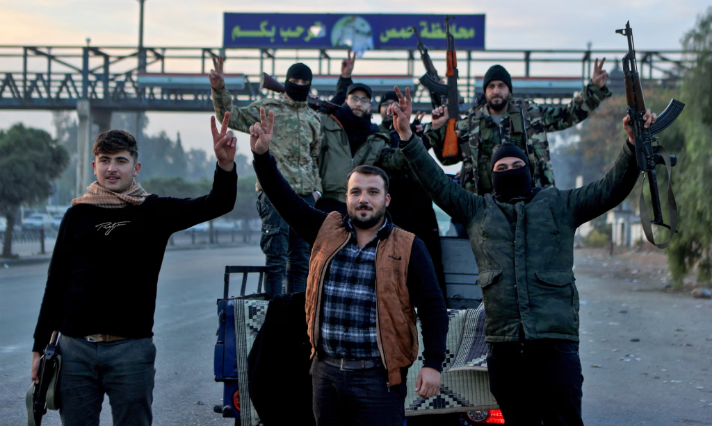 Syrian rebel fighters celebrating after rebel forces entered Syria’s third city overnight. (Image Source:: Aaref Watad / AFP / Getty Images)