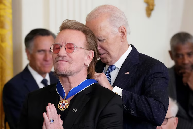 Who Are The Presidential Medal of Freedom Recipients 2025? 3 President Joe Biden presents the Presidential Medal of Freedom to singer Bono in the East Room of the White House, in Washington, D.C., Jan. 4, 2025. (Image Credit: Ken Cedeno / Reuters)