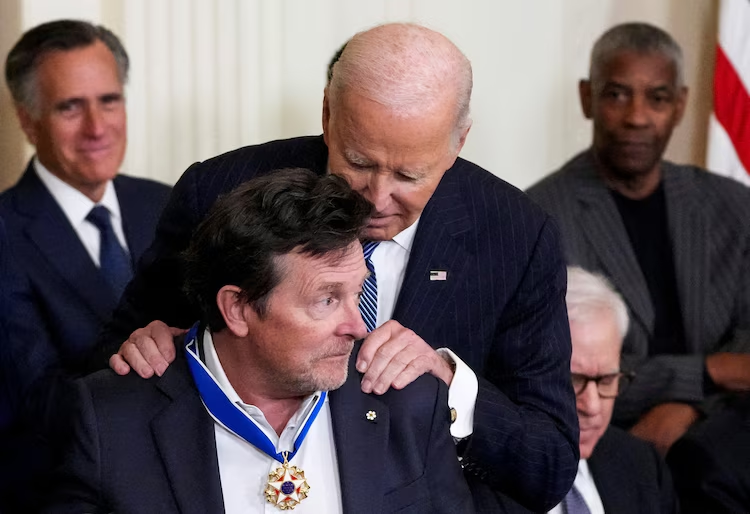 Who Are The Presidential Medal of Freedom Recipients 2025? 5 President Joe Biden presents the Presidential Medal of Freedom to iconic actor Michael J. Fox, during a ceremony in the East Room of the White House, in Washington, D.C., Jan. 4, 2025. (Image Credit: Ken Cedeno / Reuters)