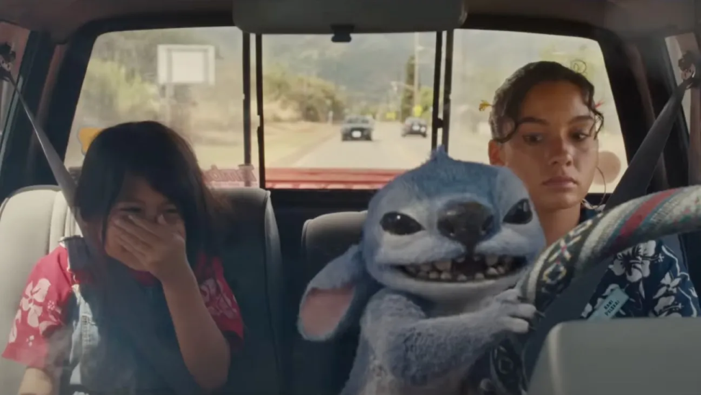 New Lilo & Stitch Live-Action Trailer: All You Need to Know 1 Stitch (voiced by Chris Sanders) with Lilo (Maia Kealoha) and Nani (Sydney Agudong) in the new Disney’s live-action ‘Lilo & Stitch’ trailer. (Image Credit: Disney)