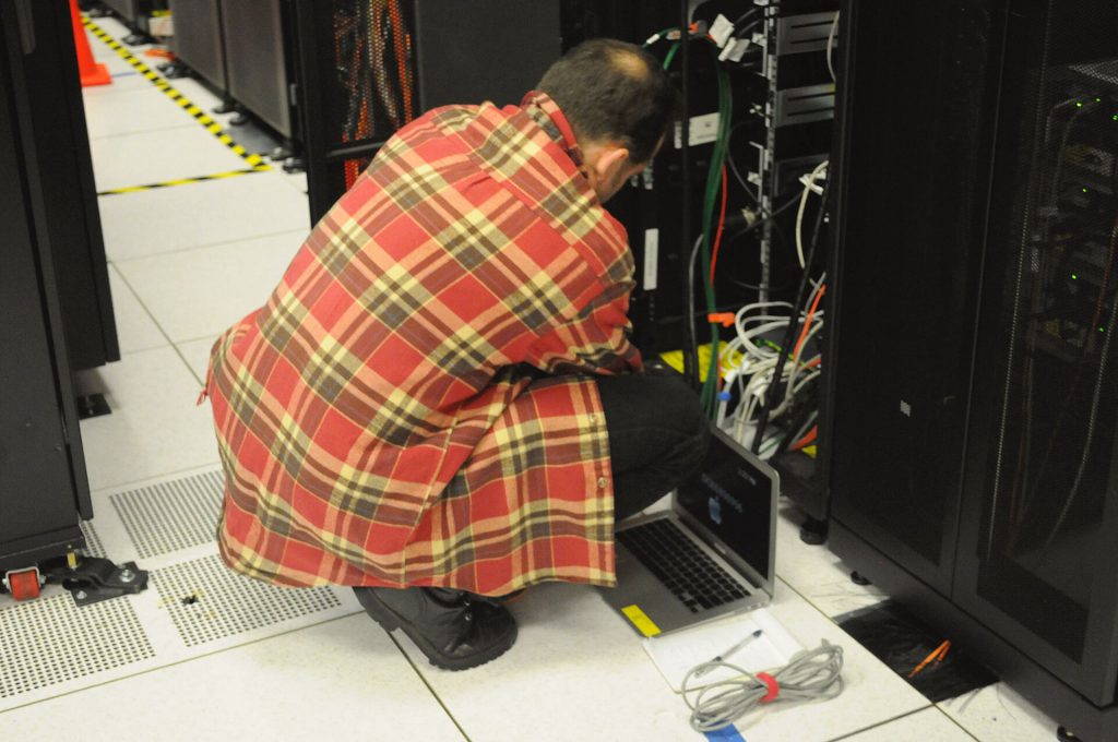 Technician with laptop working on server rack at NERSC