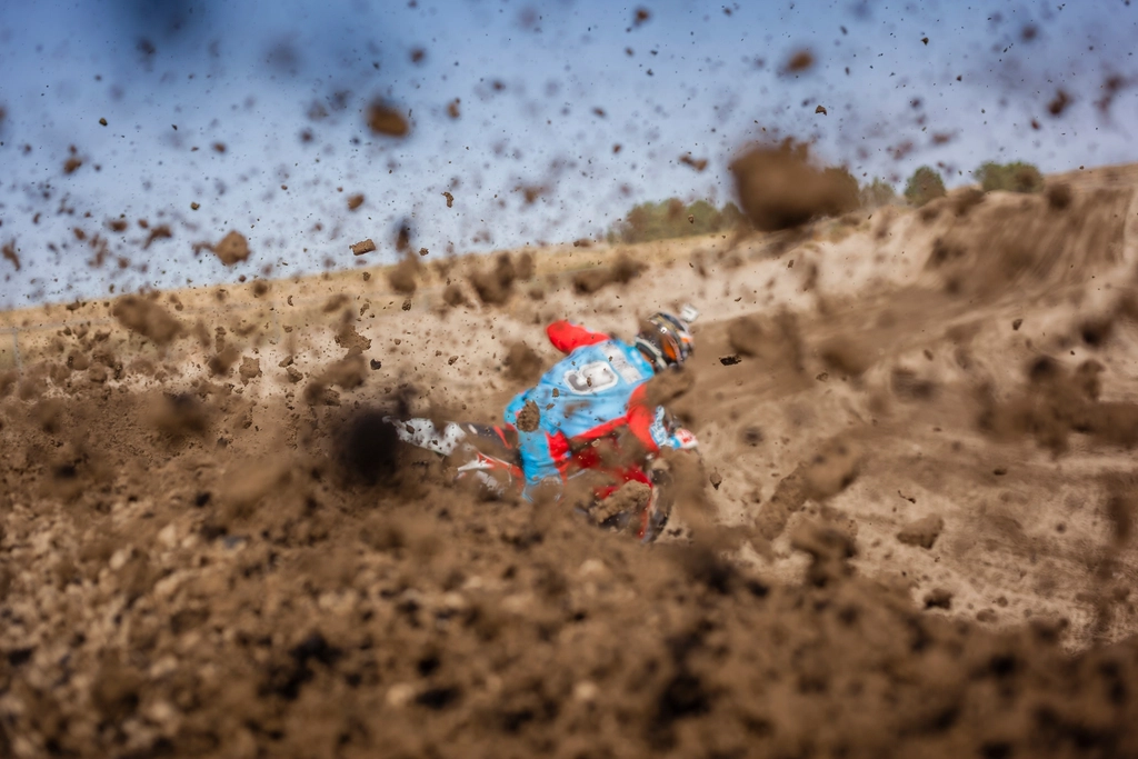 motorcyclist riding motorcycle throwing dirt