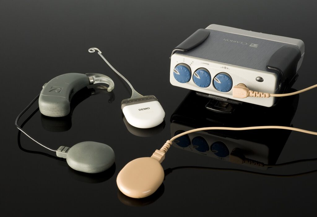Close up of a small medical device with ear clips designed for nerve stimulation to treat high blood pressure