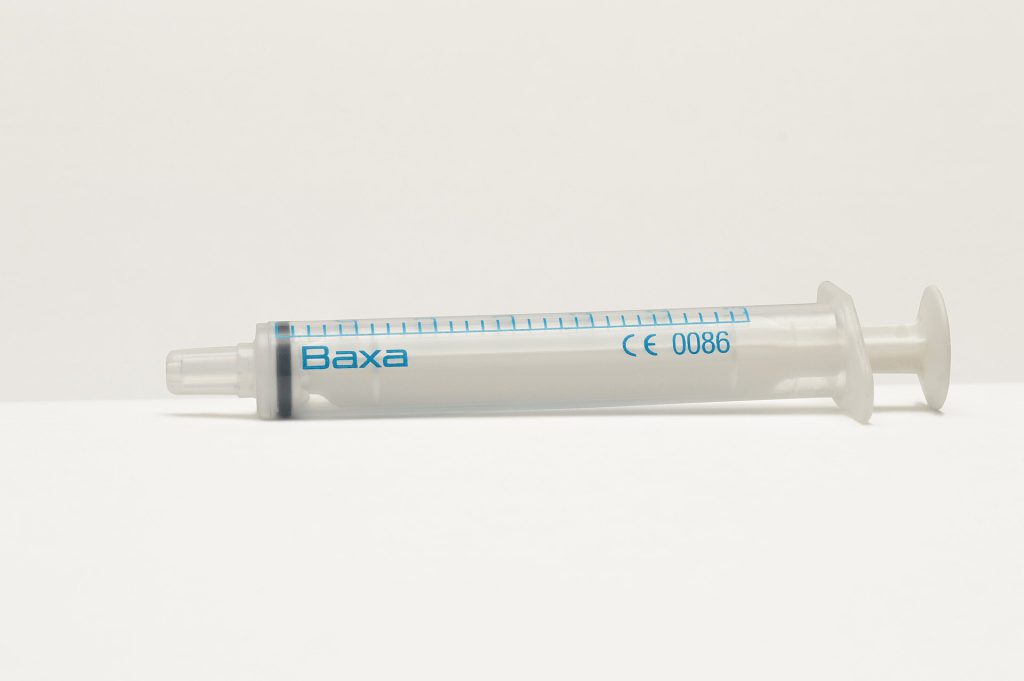 Medical syringe and vials representing high-risk cosmetic procedures regulation