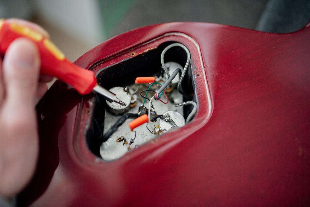 FCC Blocks Gadgets With Foreign Surveillance Chips 2 Guitar electronics repair in workshop with tools and components visible during afternoon session
