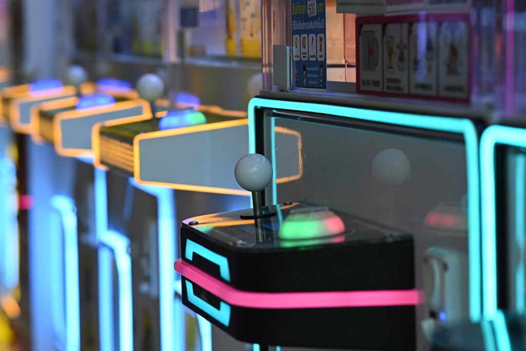 5 Forgotten 1980s Games That Redefined Gaming 2 DFC 0797 Close up of a row of retro arcade game joysticks glowing with neon blue and pink lights