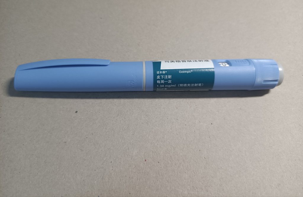 Close up of Ozempic pen injector device on a white surface