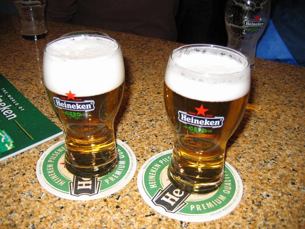 A pint of beer on a wooden pub table next to a bottle of weight-loss medication