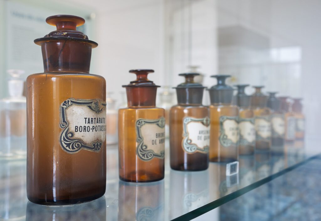 Amber glass apothecary jars with labels on a shelf, Museu do Vidro, Marinha Grande, Portugal julesvernex2