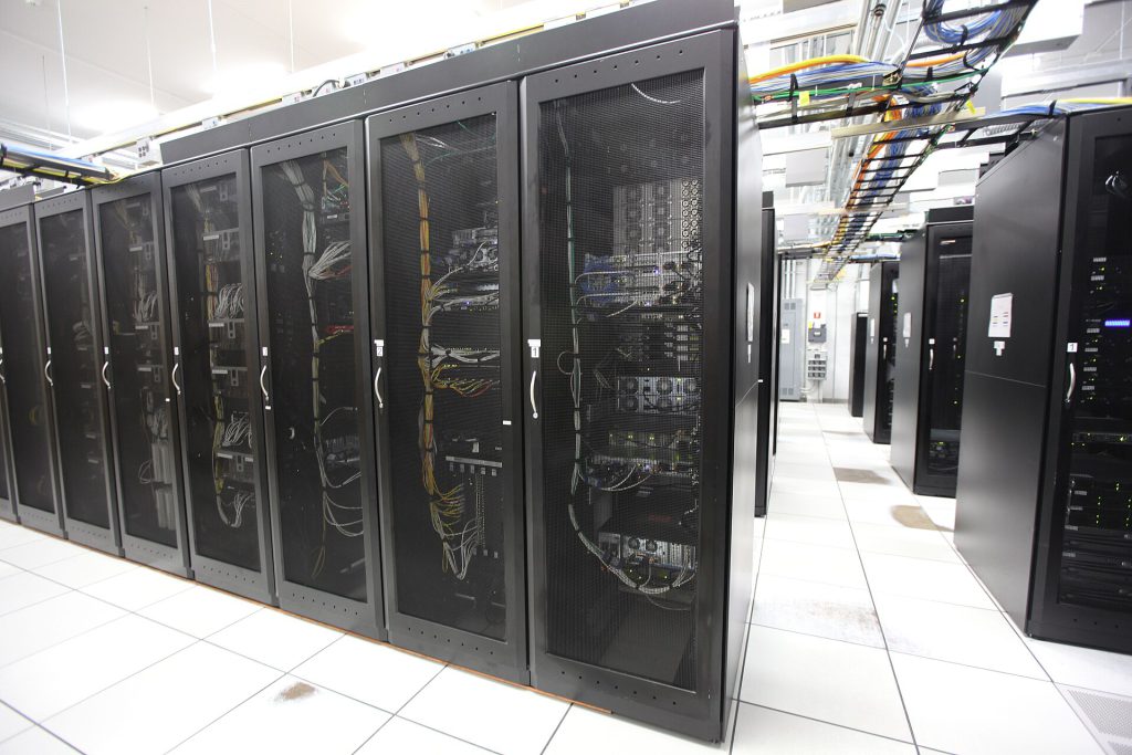 Nvidia Halts RTX 5090 Production for AI Chips Nvidia RTX 5090 graphics card next to AI data center server rack