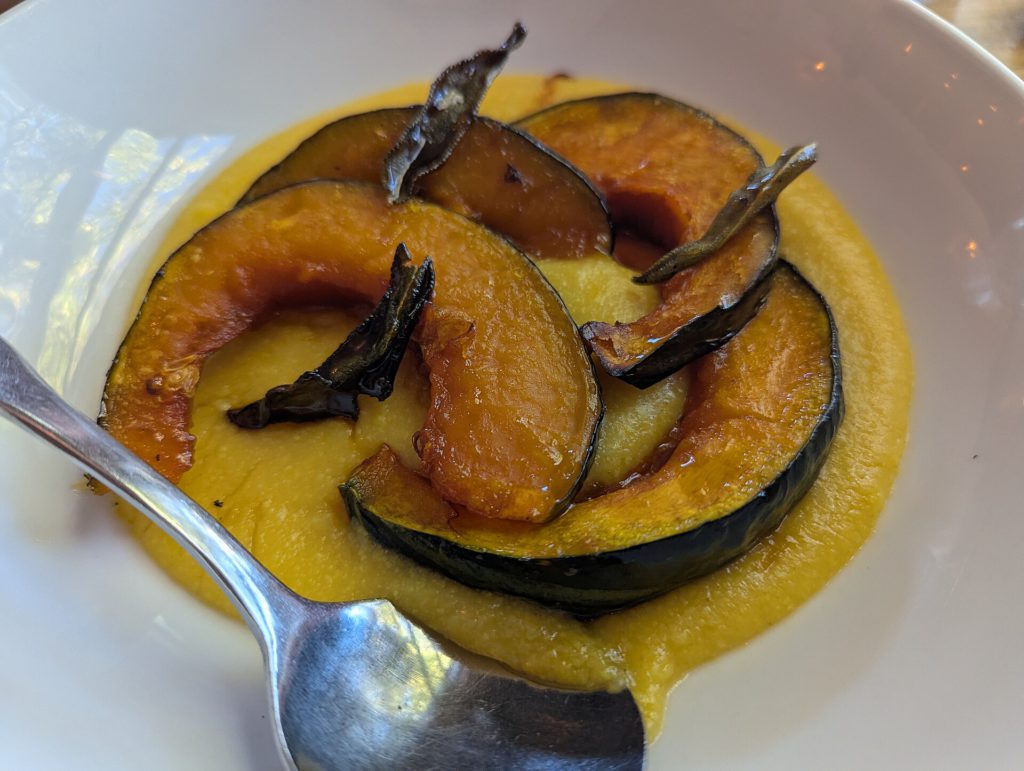 Roast chicken with kabocha squash wedges and pumpkin congee in bowls