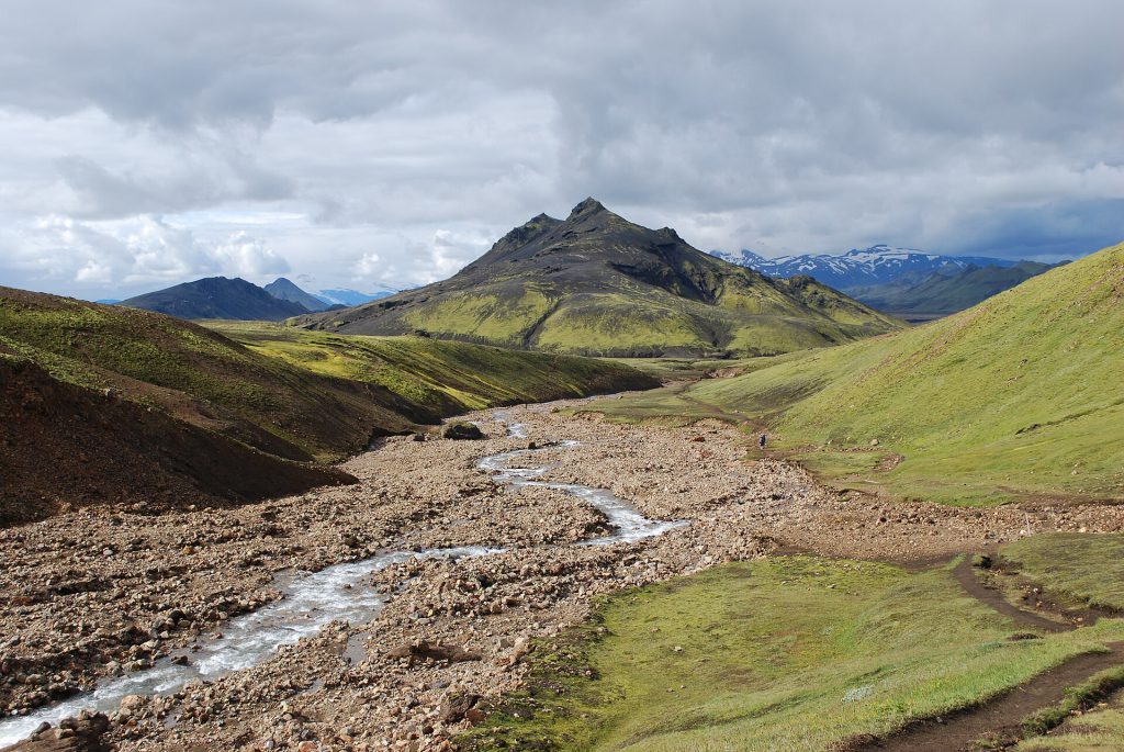 Sustainable Travel Is Mainstream, Not Niche, Skift Data Shows Travelers hiking on a trail in a natural landscape representing sustainable travel