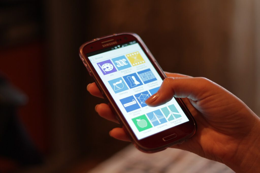 A smartphone displaying an AI chatbot interface on a desk next to a notebook