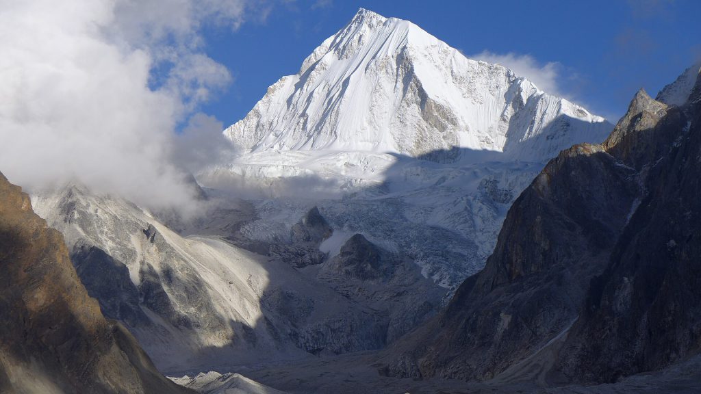 Snowy mountain landscape with unstable glacial lake in the Himalayas